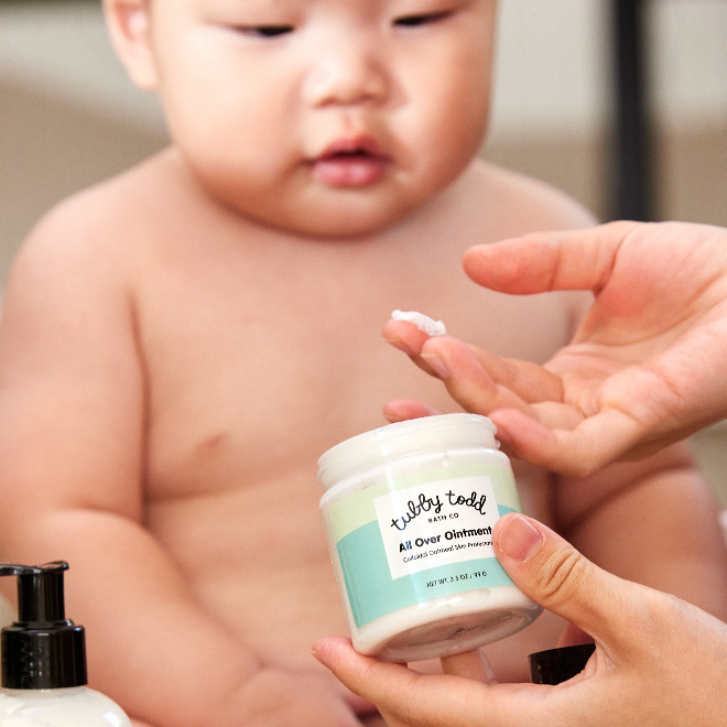 Mother scooping up All Over Ointment onto hand