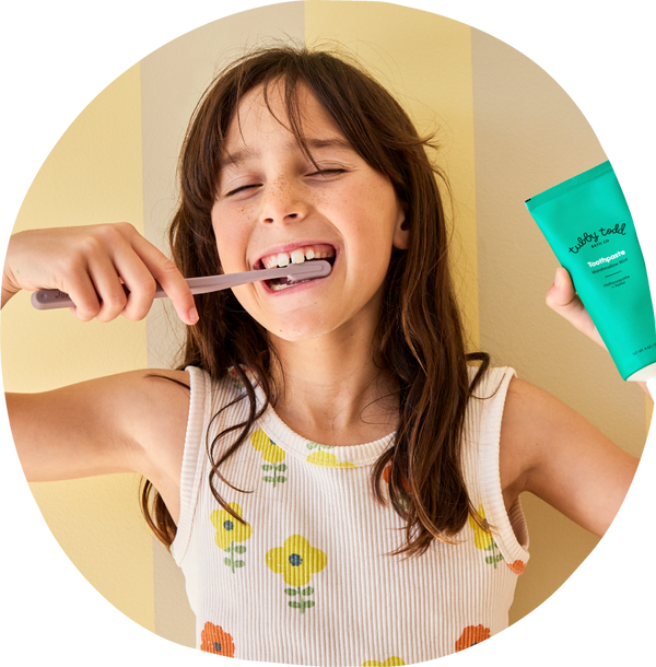 girl brushing her teeth with Tubby Todd toothpaste