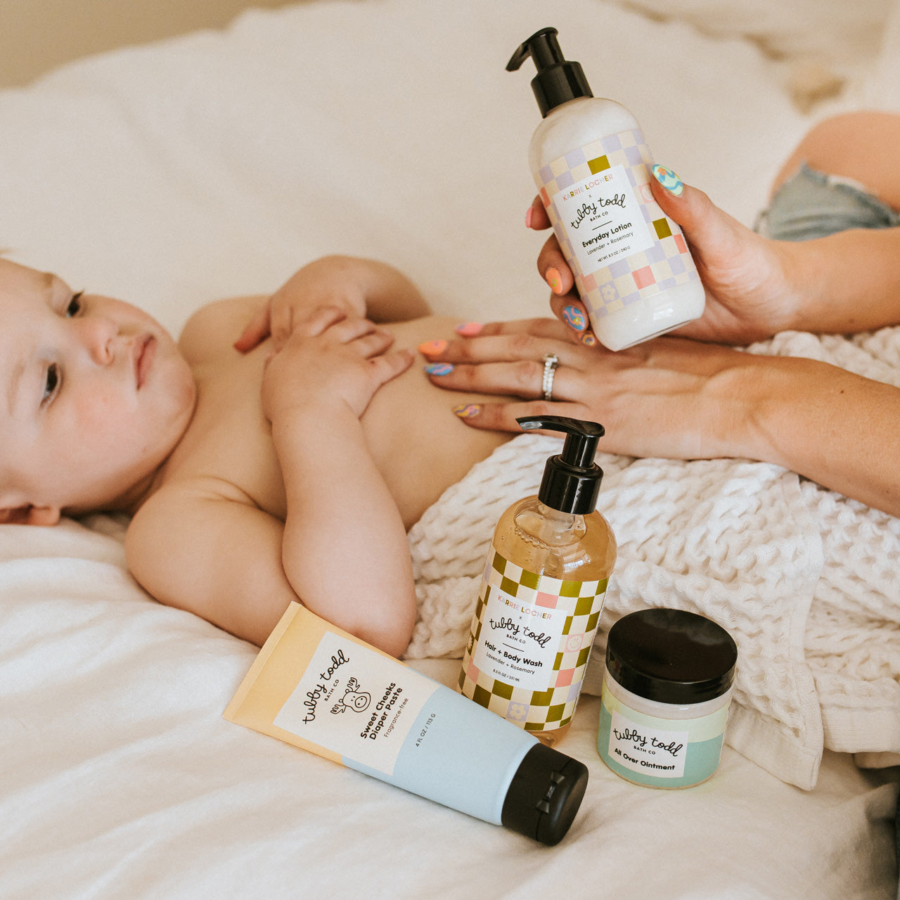 Karrie Locher applying Baby Bundle products to toddler on bed