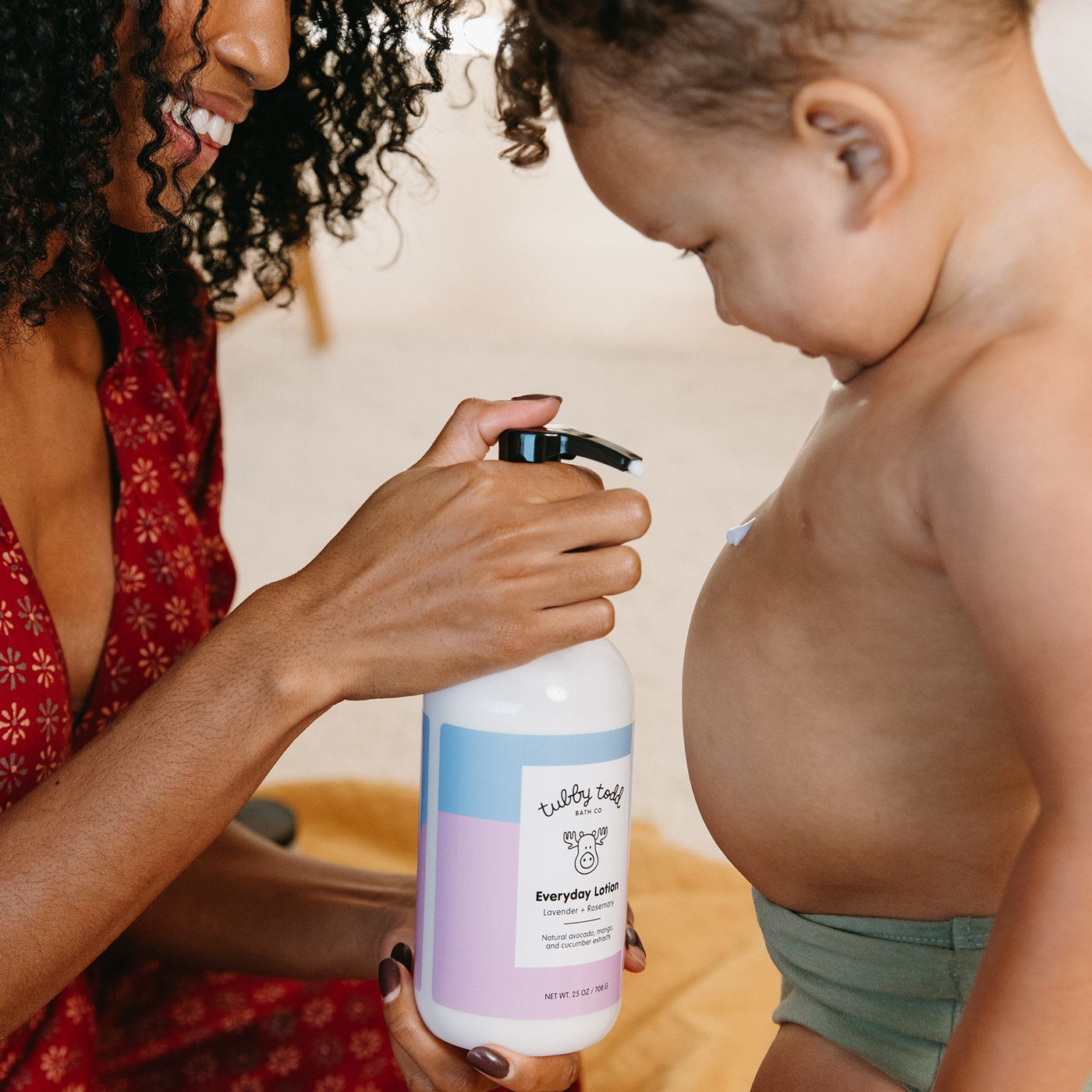 Mom is applying the Everyday Lotion to her baby's belly