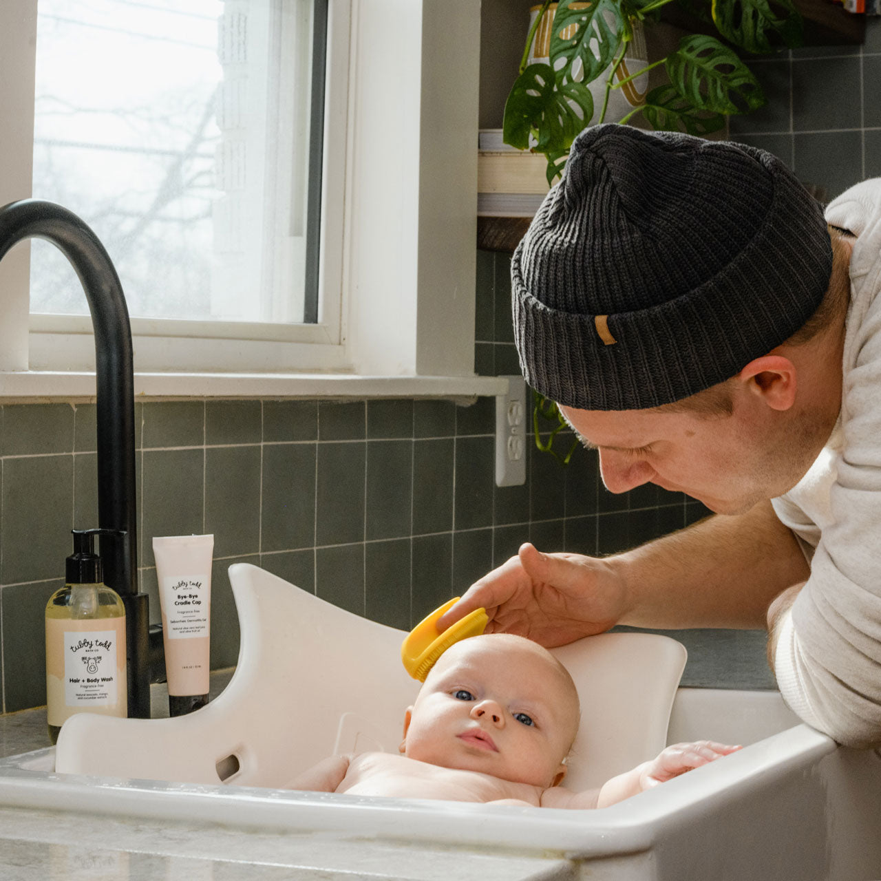 Dad washing baby's scalp with Cradle Cap Brush in sink bath