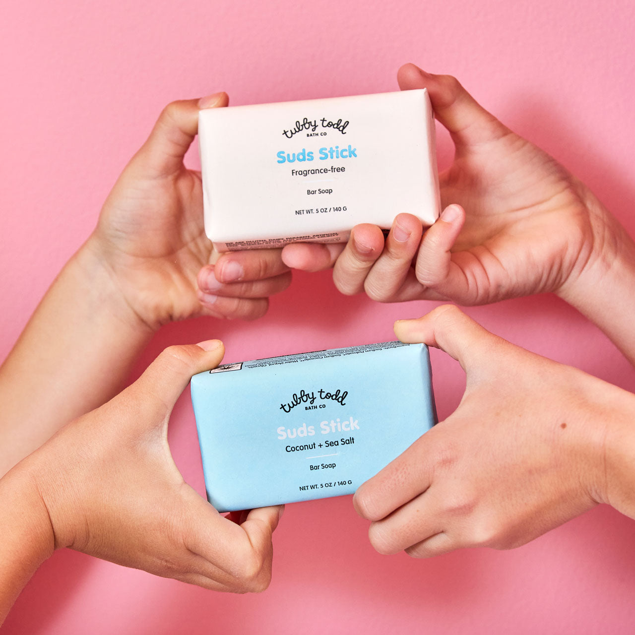 Girls hands holding Coconut + Sea Salt and Fragrance-free Suds Stick Bar Soap